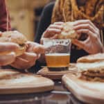 Hipster Friends In Fast Food Rastaurant. Focus Is On Beer